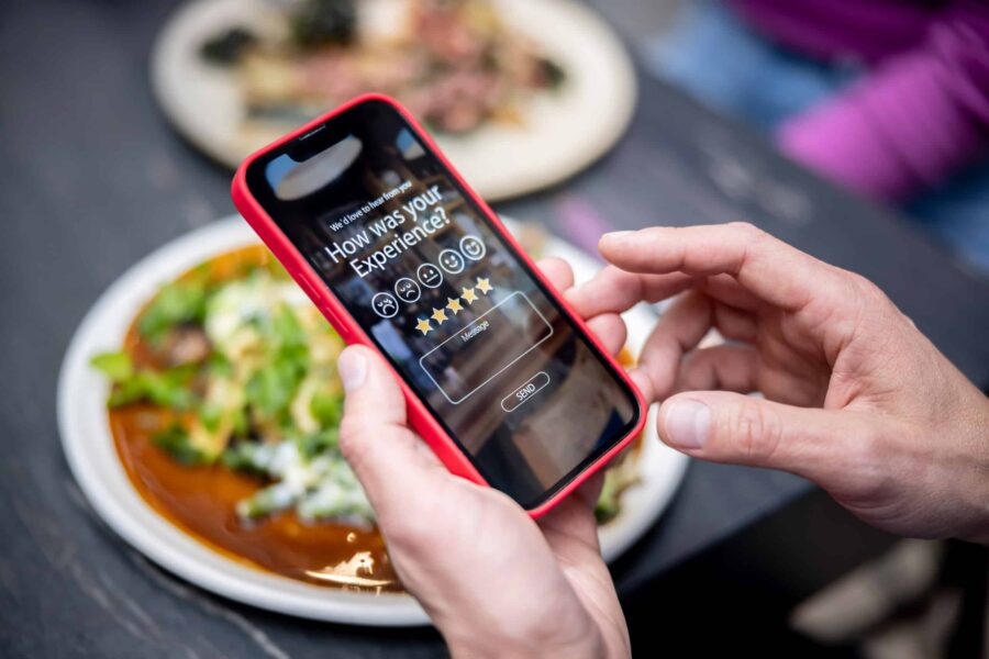 person taking a survey on their phone over a plate of food.